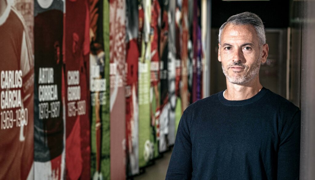 Carlos Vicens posa frente a un mural con leyendas del SC Braga. Daniel Ribeiro/Coaches’ Voice.
